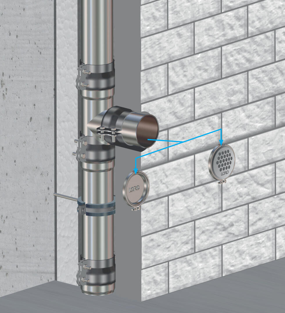 Die digitale Abbildung zeigt ein an einer Betonwand befestigtes Regen-Ablaufrohr aus Metall, das hinter der Fassadendämmung verläuft und über eine Revisionsverbindung mit rundem, perforiertem Deckel und abnehmbarer Kappe verbunden ist.