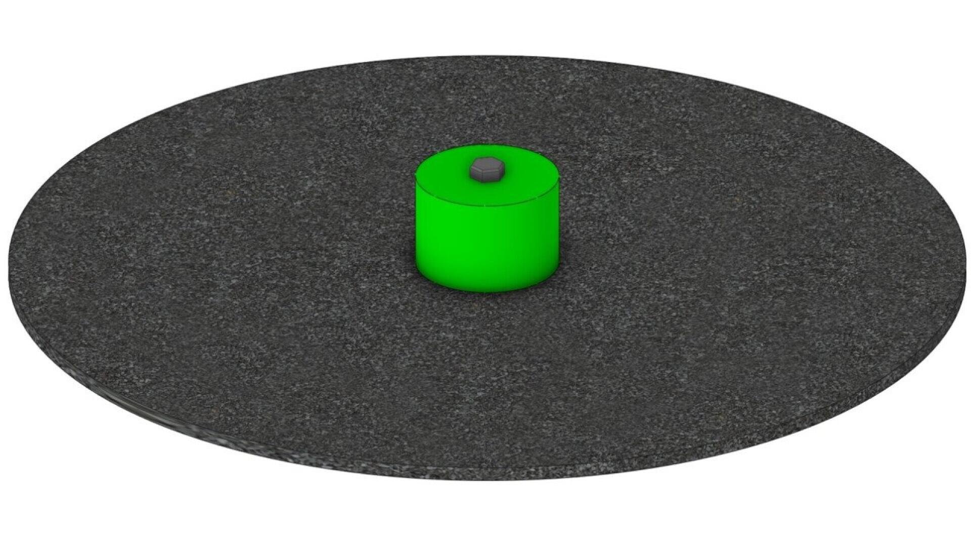 A black circular base with a small, bright green cylindrical object standing upright at the center, featuring a dark circle on top.