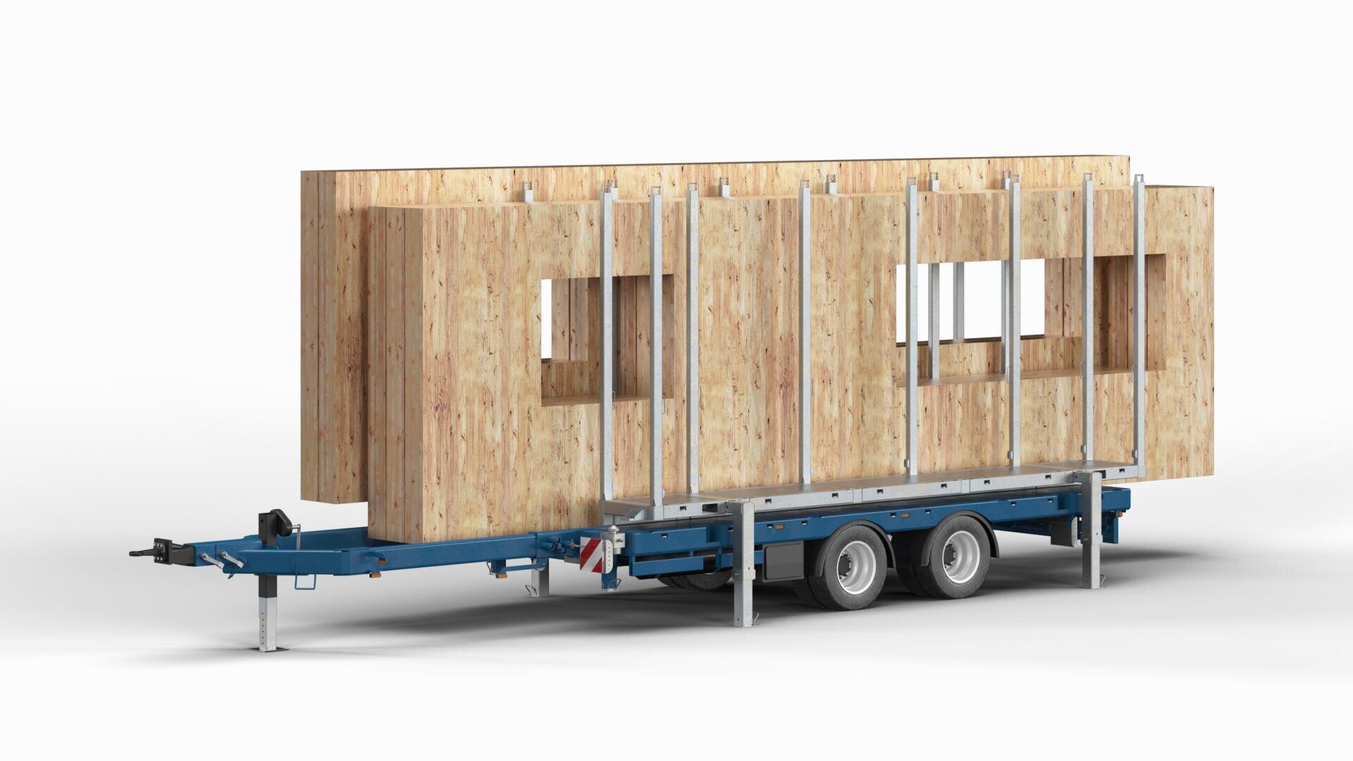 A blue trailer with two wheels carries large prefabricated wooden wall panels, some with window openings, held upright by vertical metal supports against a plain white background.