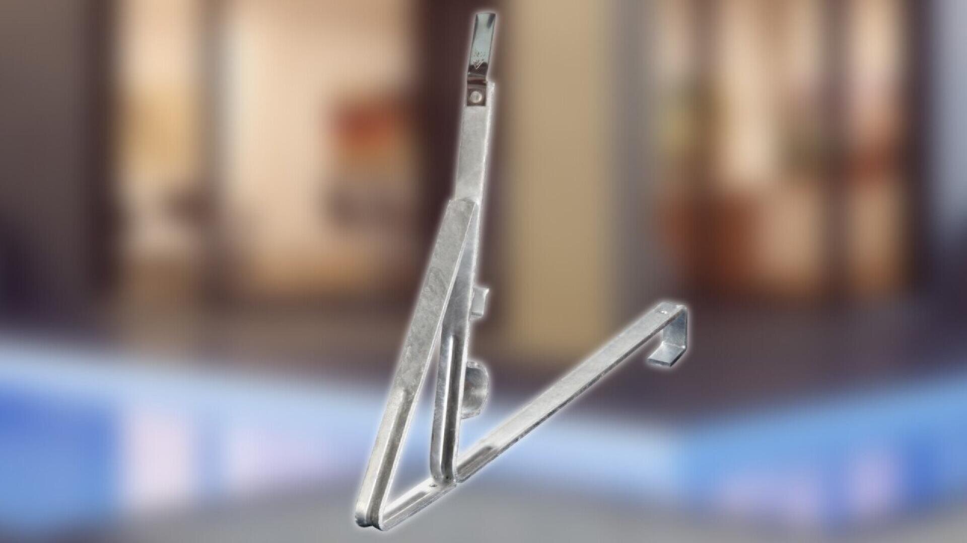 A close-up of a metal folding bracket with hinges and mounting holes, displayed against a blurred indoor background.