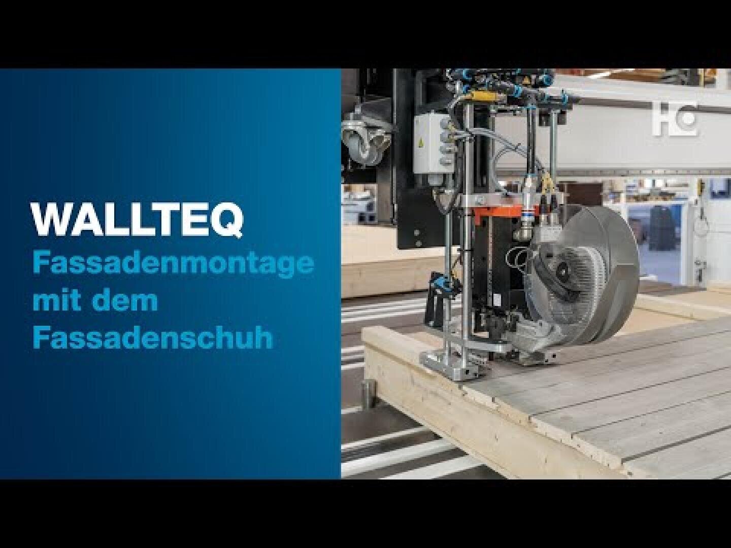 Eine Maschine mit der Aufschrift WALLTEQ montiert Gebäudefassaden in einer Fabrik. Der deutsche Text lautet: Fassadenmontage mit dem Fassadenschuh, das heißt Fassadenmontage mit dem Fassadenschuh.