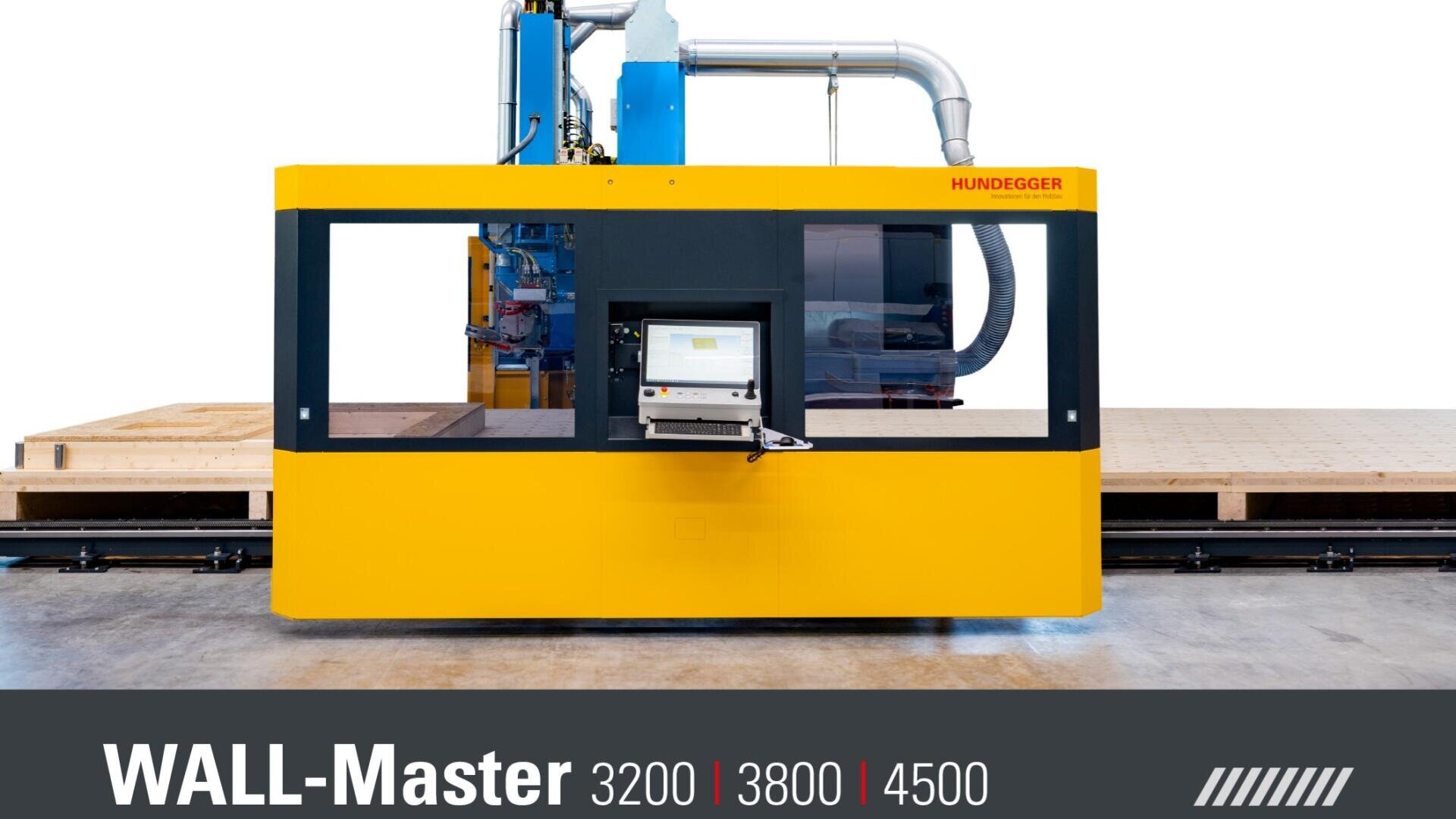 Eine Hundegger WALL-Master-Industriemaschine mit gelbem und schwarzem Gehäuse steht in einer Fabrikhalle, mit einem Kontrollbildschirm an der Vorderseite. Der Text darunter lautet WALL-Master 3200 | 3800 | 4500.