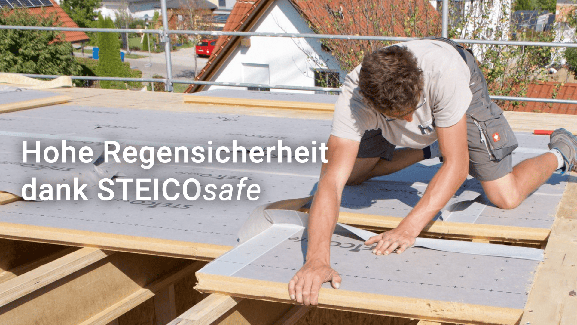 Ein Mann montiert bei strahlendem Sonnenschein eine Abdichtungsbahn auf einem Holzdachstuhl. Der Text lautet: „Hohe Regensicherheit dank STEICOsafe“.