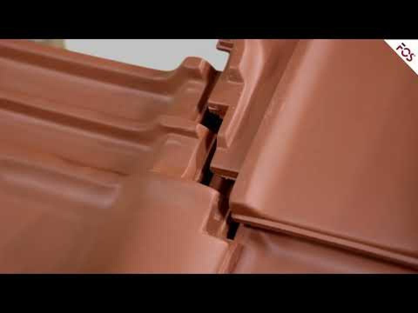 Close-up of interlocking brown ceramic roof tiles lined up, showing their overlapping edges and interlocking mechanism.