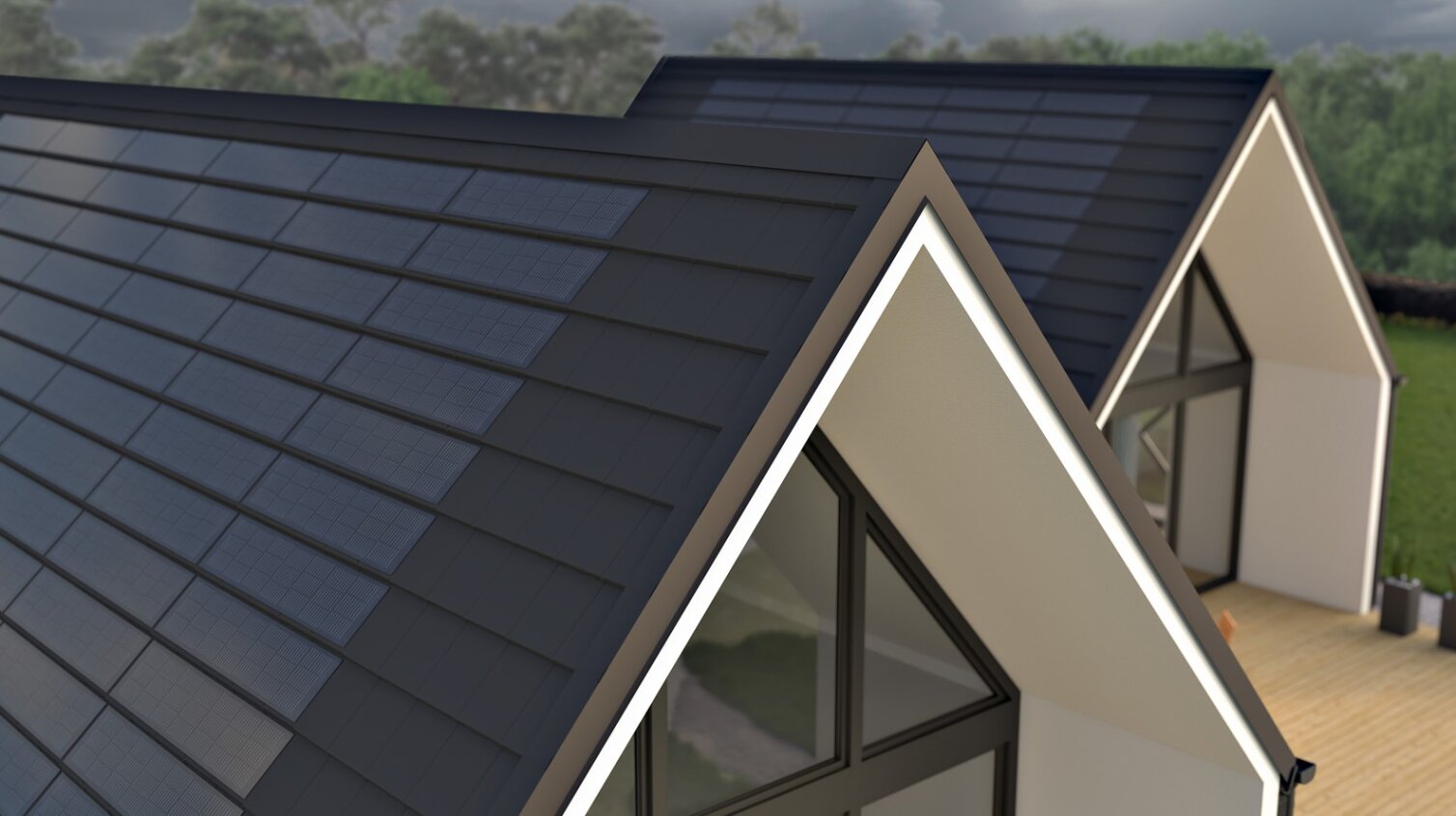 Moderne Häuser mit steilen, dreieckigen Dächern, bedeckt mit dunklen Solardachziegeln. Große Fenster und eine hölzerne Außenterrasse sind zu sehen, mit Bäumen und einem bewölkten Himmel im Hintergrund.